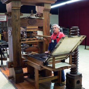 Peter Small demonstrating the use of the Gutenberg press at the International Printing Museum.
